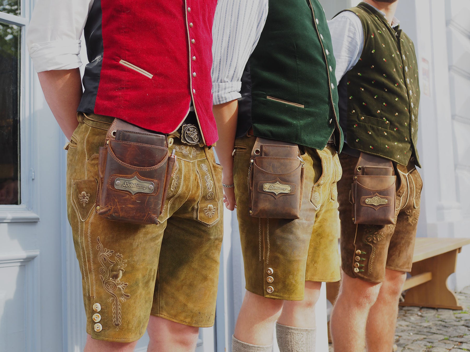 Drei Kellner tragen Lederhosen mit Hodalump Kellnertaschen aus Echtleder.